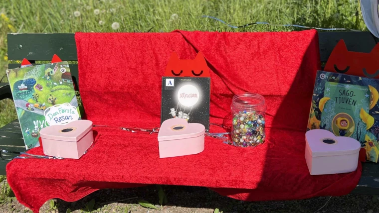 Foto med sagor fint uppställda i trädgården på en bänk klädd i röd sammet.