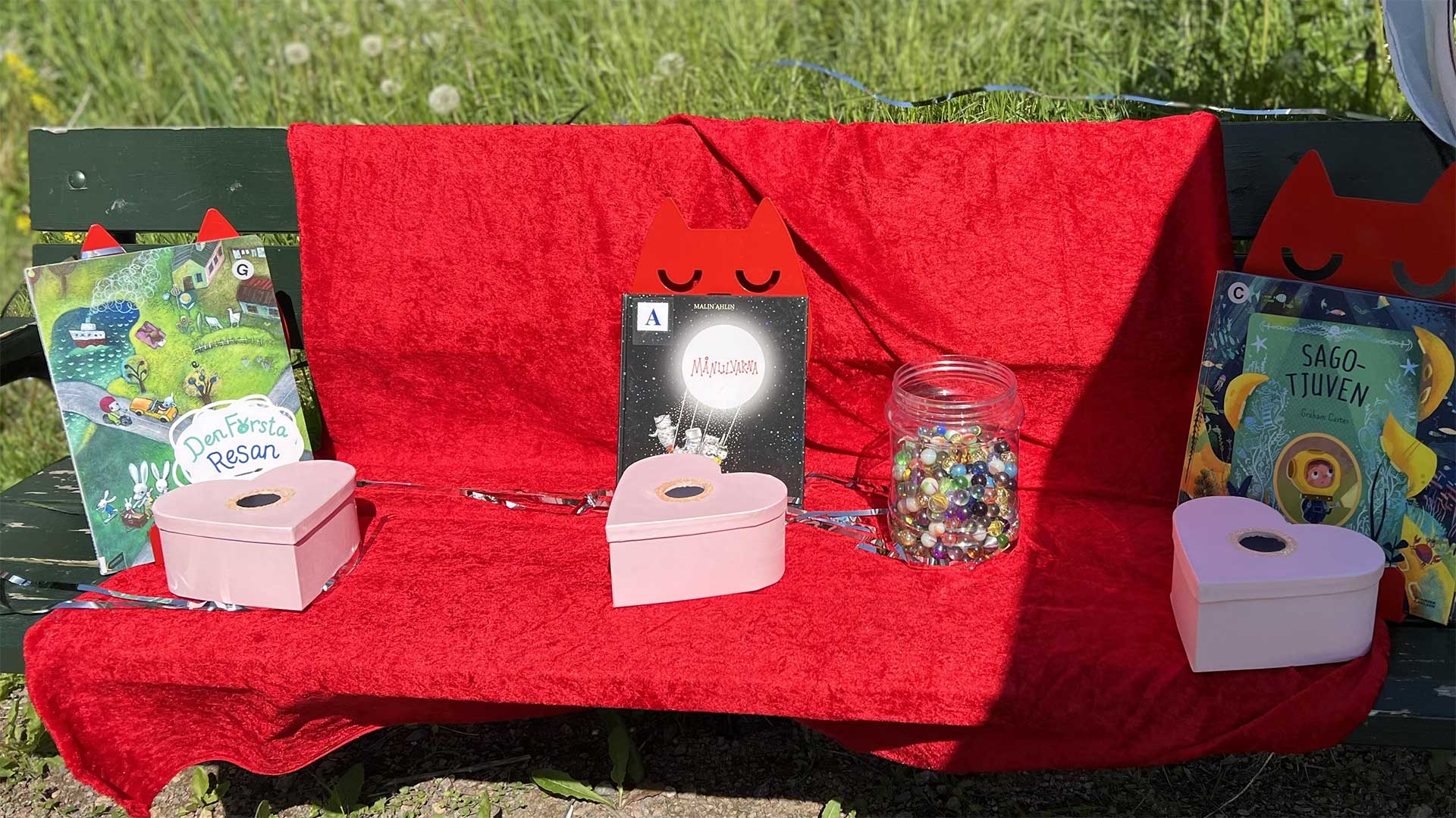 Foto med sagor fint uppställda i trädgården på en bänk klädd i röd sammet.