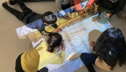 Foto på några barn som skapar sagor med hjälp av med digital projektion