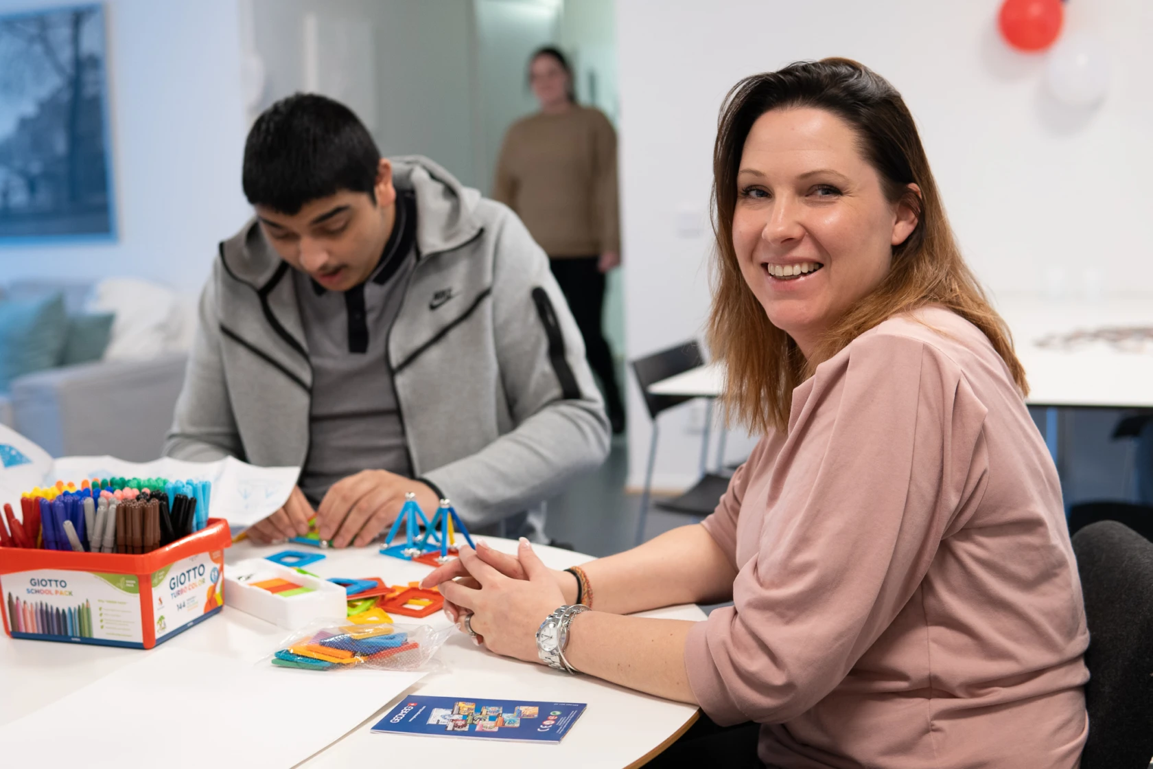 En man och en kvinna sitter vid ett bord och pysslar