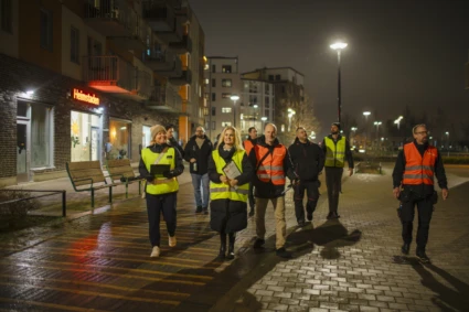 En grupp personer i reflexväst rör sig i ett bostadsområde.