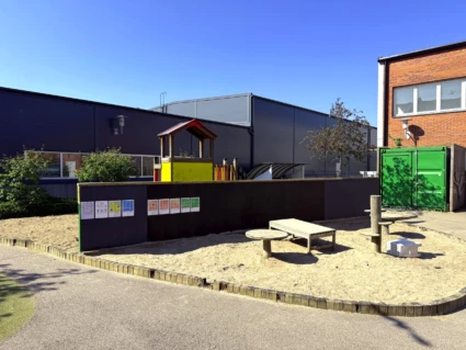 Utemiljö på Viktoria förskola. Stor sandlåda, klätterställning och pedagogik.