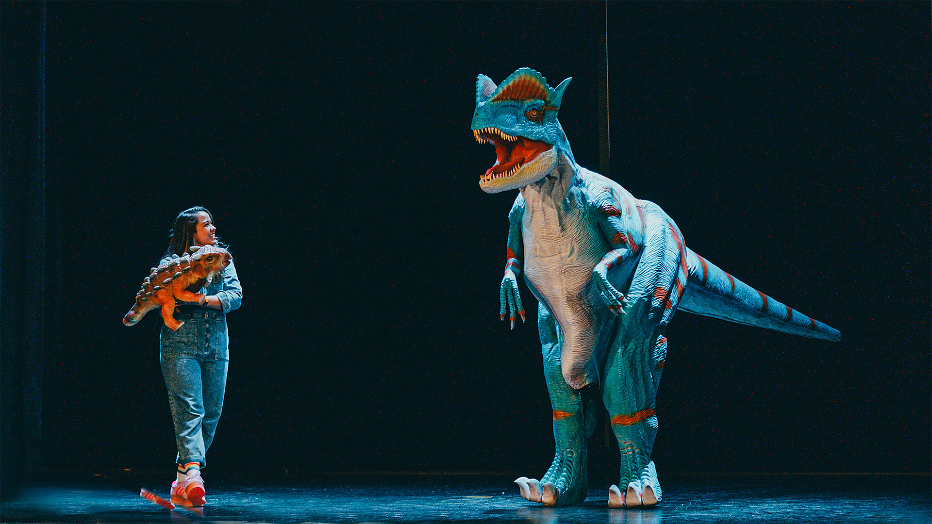 En dinosaurie och en människa på en scen.