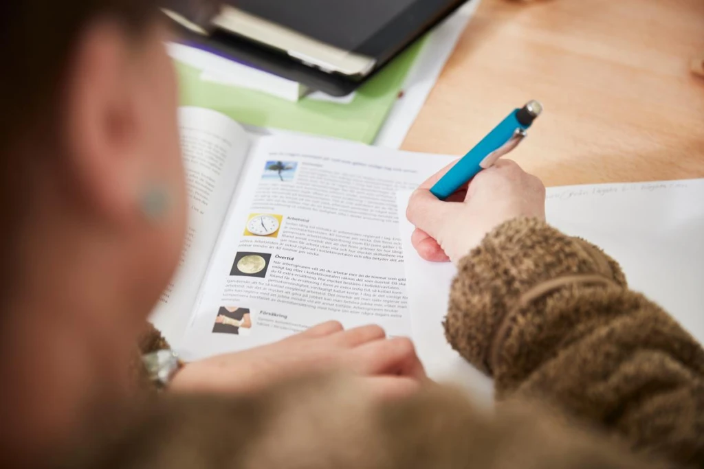 kvinna som skriver i en bok.