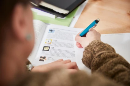 kvinna som skriver i en bok.