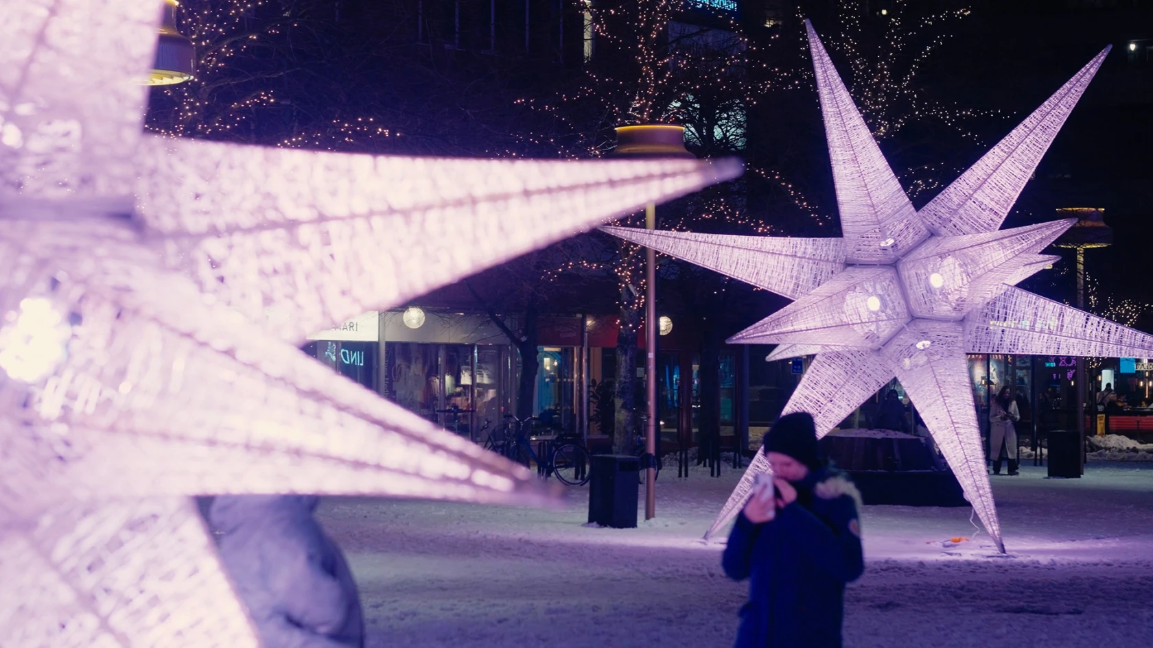 Person som fotar ljusverket Sjärnfall på Mäster Palms plats