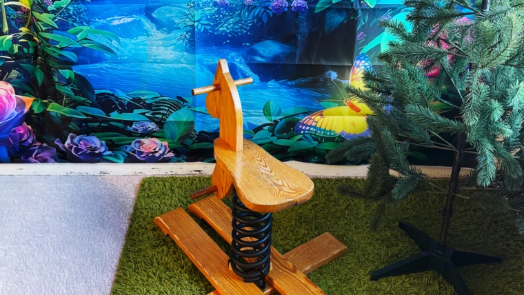 Bild på gunghäst med ett motiv av havet i bakgrunden.