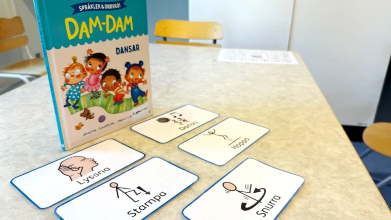 Boken Dam-Dam dansar med tillhörande kort där det står lyssna, dansa, stampa, hoppa och snurra.
