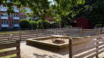 Utemiljön på Tallkottens förskola har en stor sandlåda, gungor och grönska.
