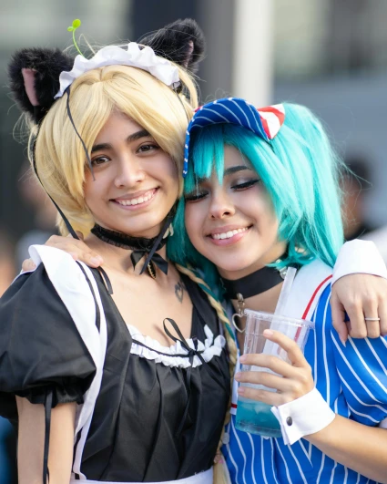 Två personer utklädda i cosplaykostymer som håller om varandra och ler.