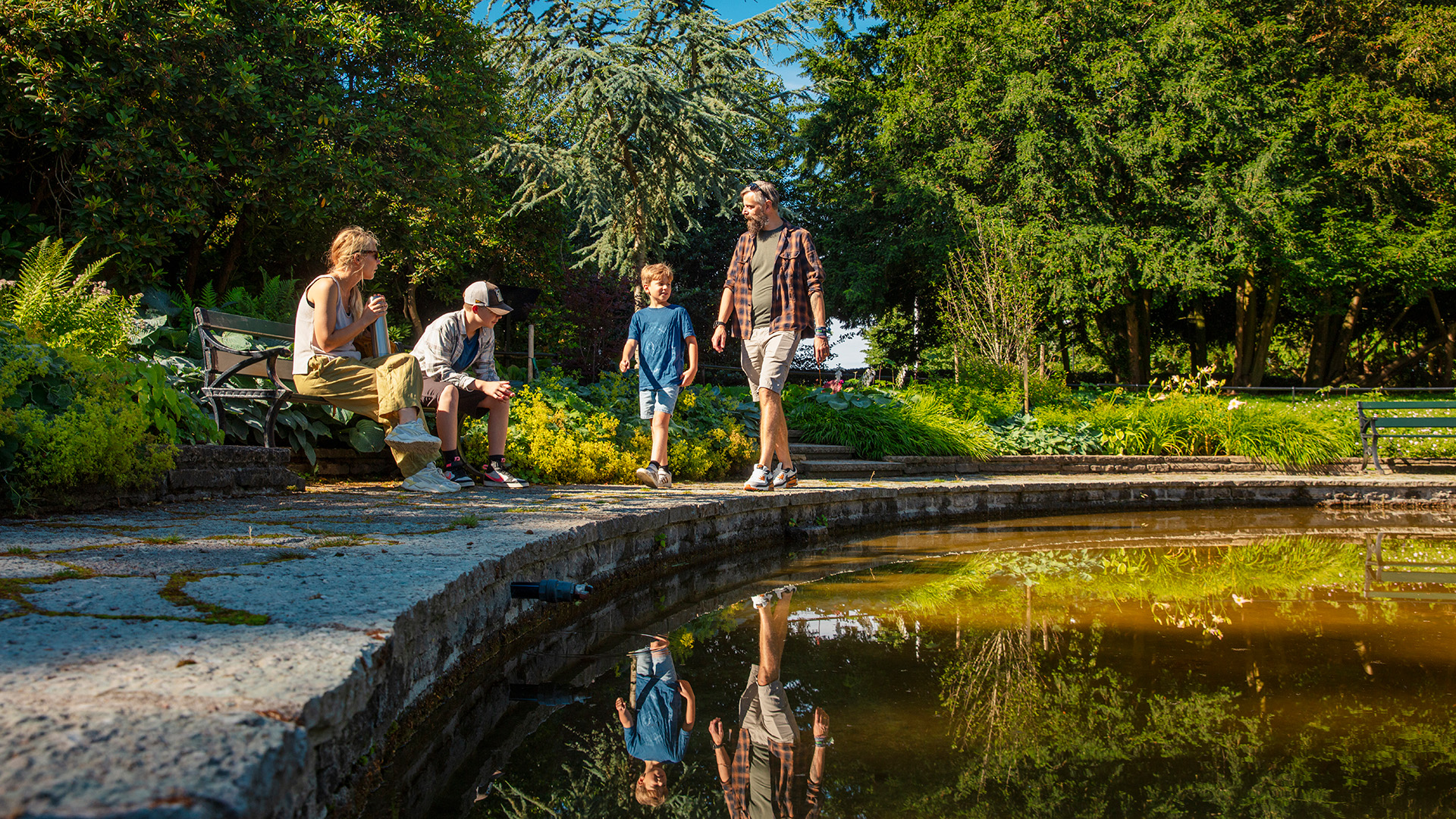 Människor vid damm i kulturparken Vikingsbergsparken.