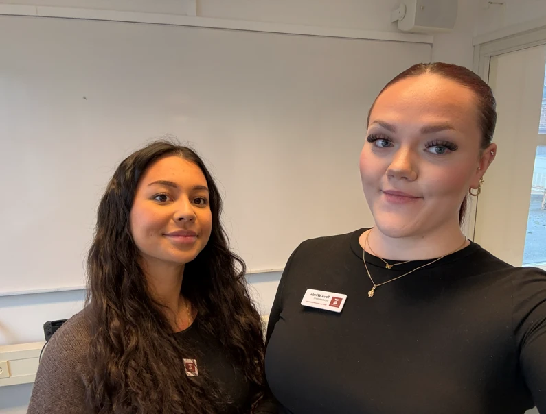 Två kvinnor i svarta tröjor med namnskyltar från vård- och omsorgsförvaltningen