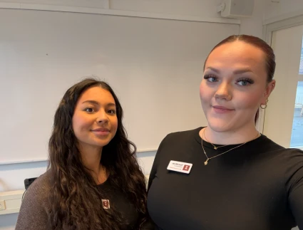 Två kvinnor i svarta tröjor med namnskyltar från vård- och omsorgsförvaltningen