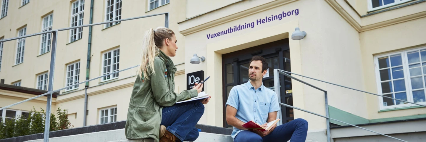 En kvinna och en man som sitter utanför en byggnad