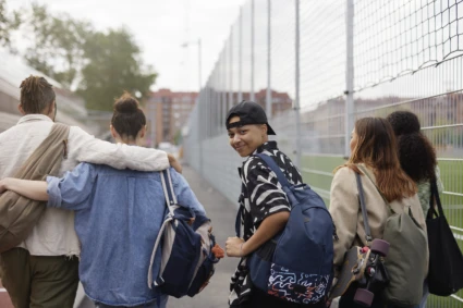 Fem ungdomar i grupp, varav en av dem tittar bak och in i kameran och ler.