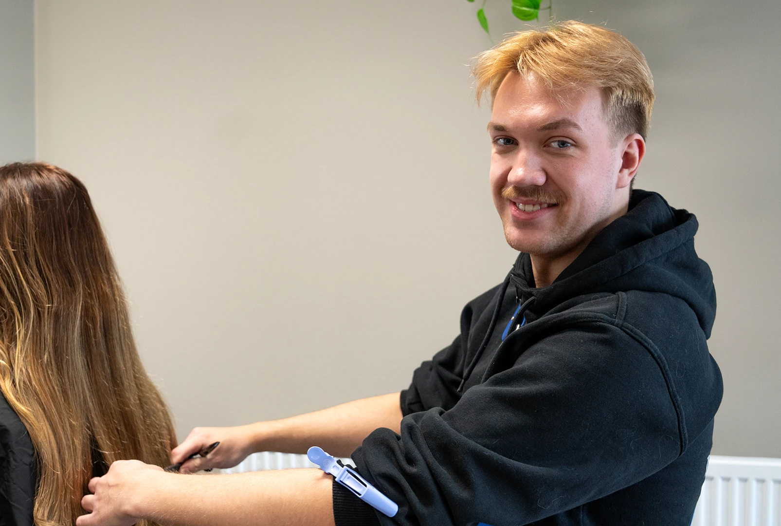 En tidigare elev på frisör- och stylistprogrammet på sin arbetsplats