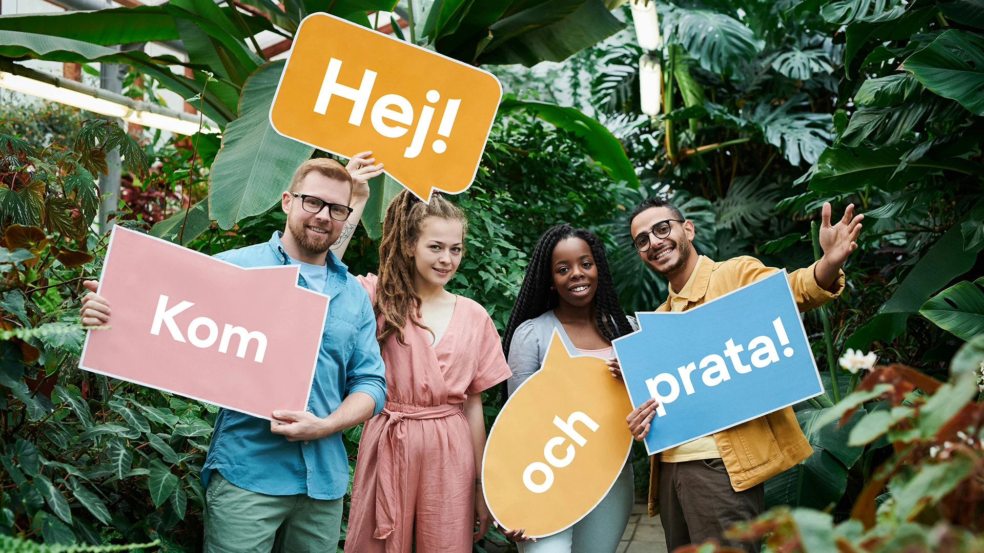 Fyra personer står framför gröna växter och håller i varsin färgglad pratbubbla med orden: "Hej!" "Kom" "och" "prata!"