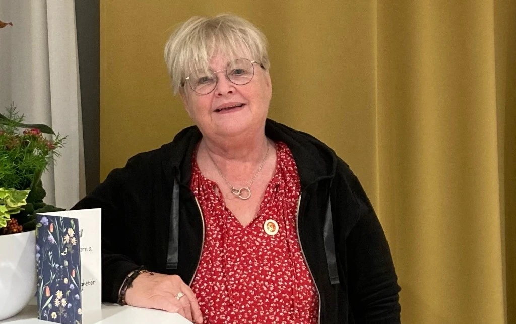 Kvinna i röd topp och svart tröja