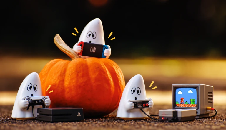 Höstlovets tre spöken spelar olika tv-spel. Ett av spökena sitter på en stor, orange pumpa.