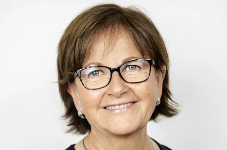 Bild på en kvinna som tittar in i kameran och ler