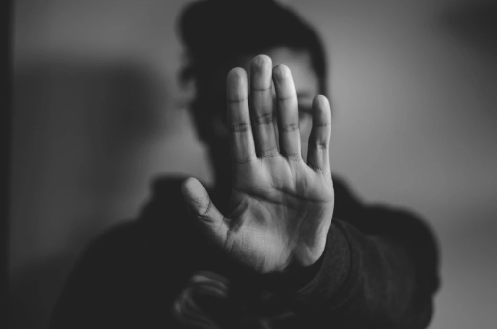 Person som håller upp en hand framför kameran