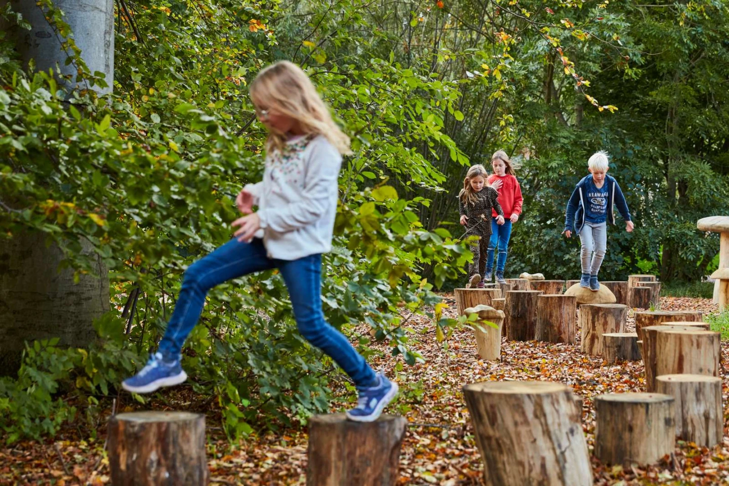 barn leker på en hinderbana i en skog