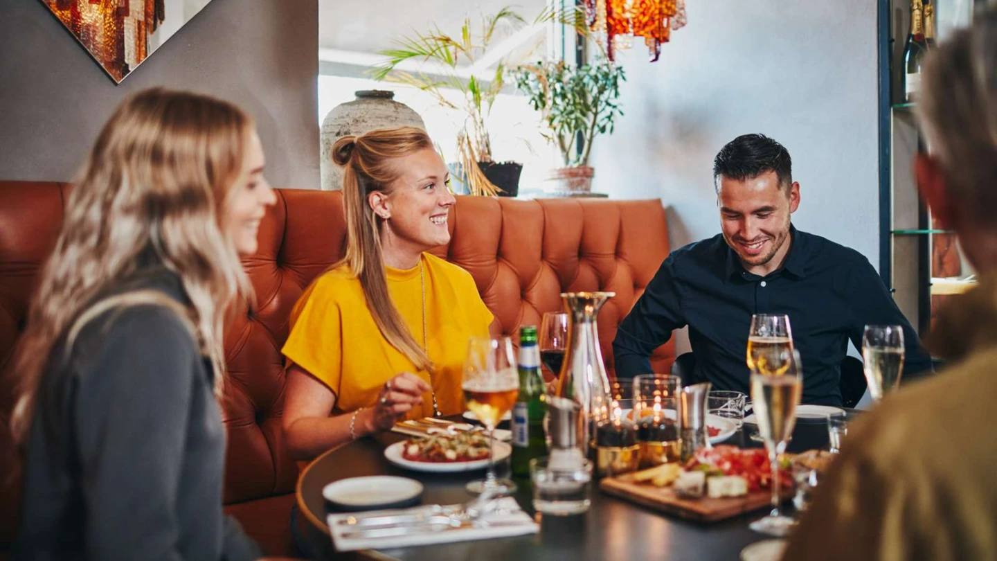 3 personer vid ett bord på en restaurang.