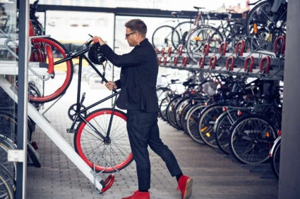 En man parkerar en cykel i ett cykelställ.