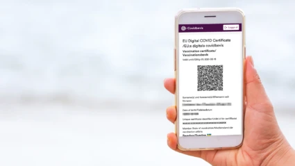 Hand som håller i mobil med vaccinationsbevis