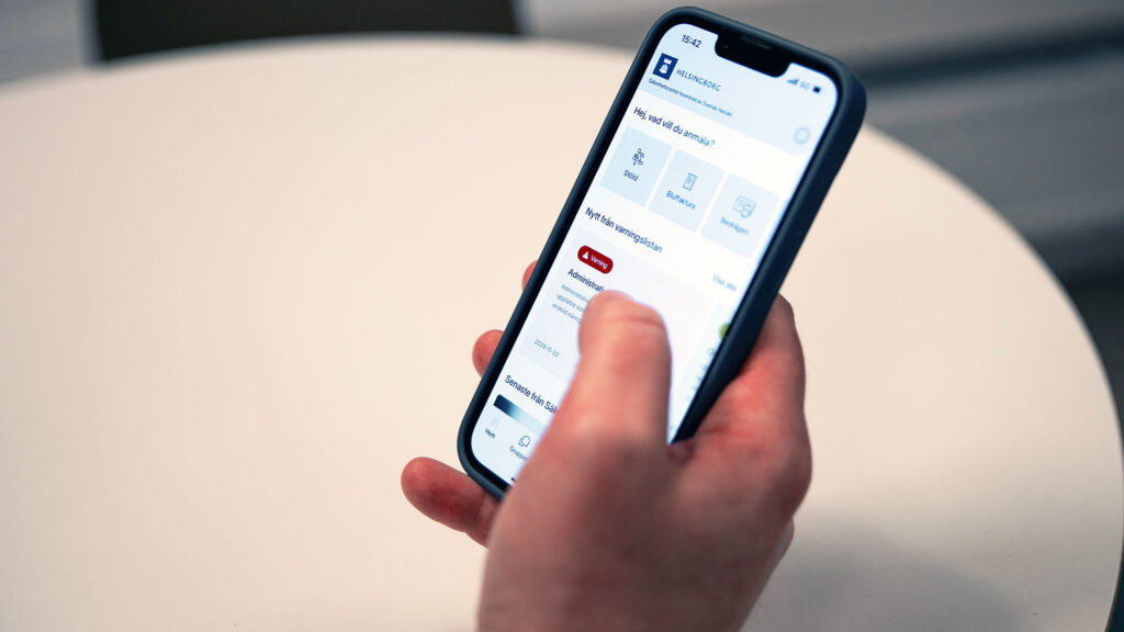 En hand håller en mobiltelefon.