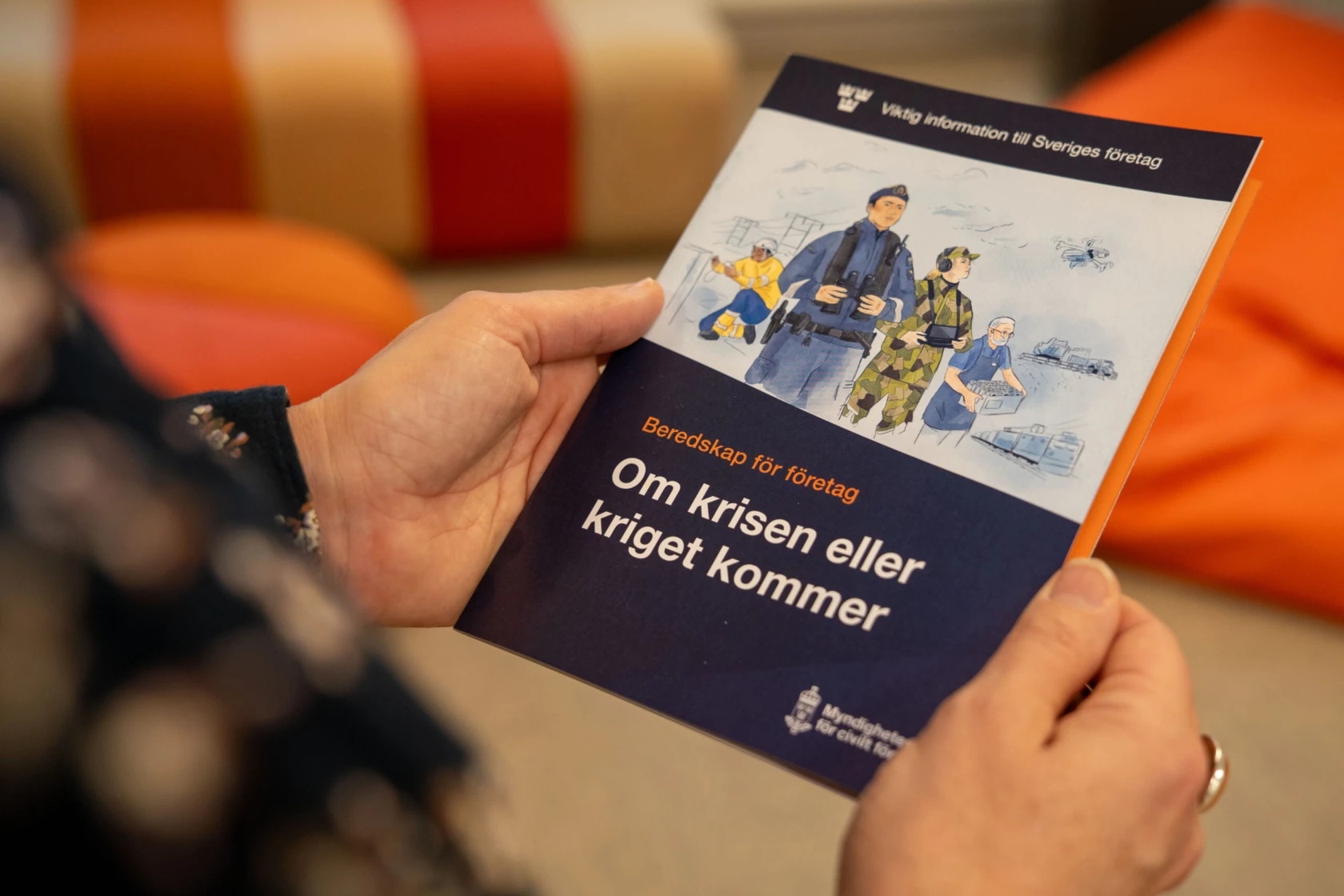 Händer håller broschyr från Myndigheten för civilt försvar