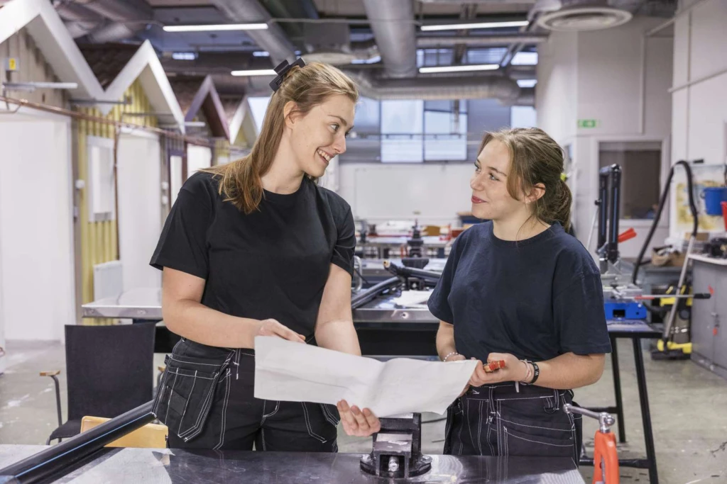 VVS-arbetare visar ritning för praoelev.