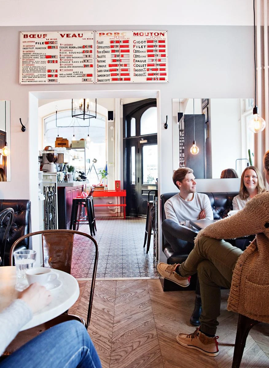 Etoile cafe, ett gäng sitter och pratar vid ett bord. Typisk fransk inredning.