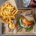 Hamburgare och pommes med dippsås upplagt på en metallbricka på Brödernas.