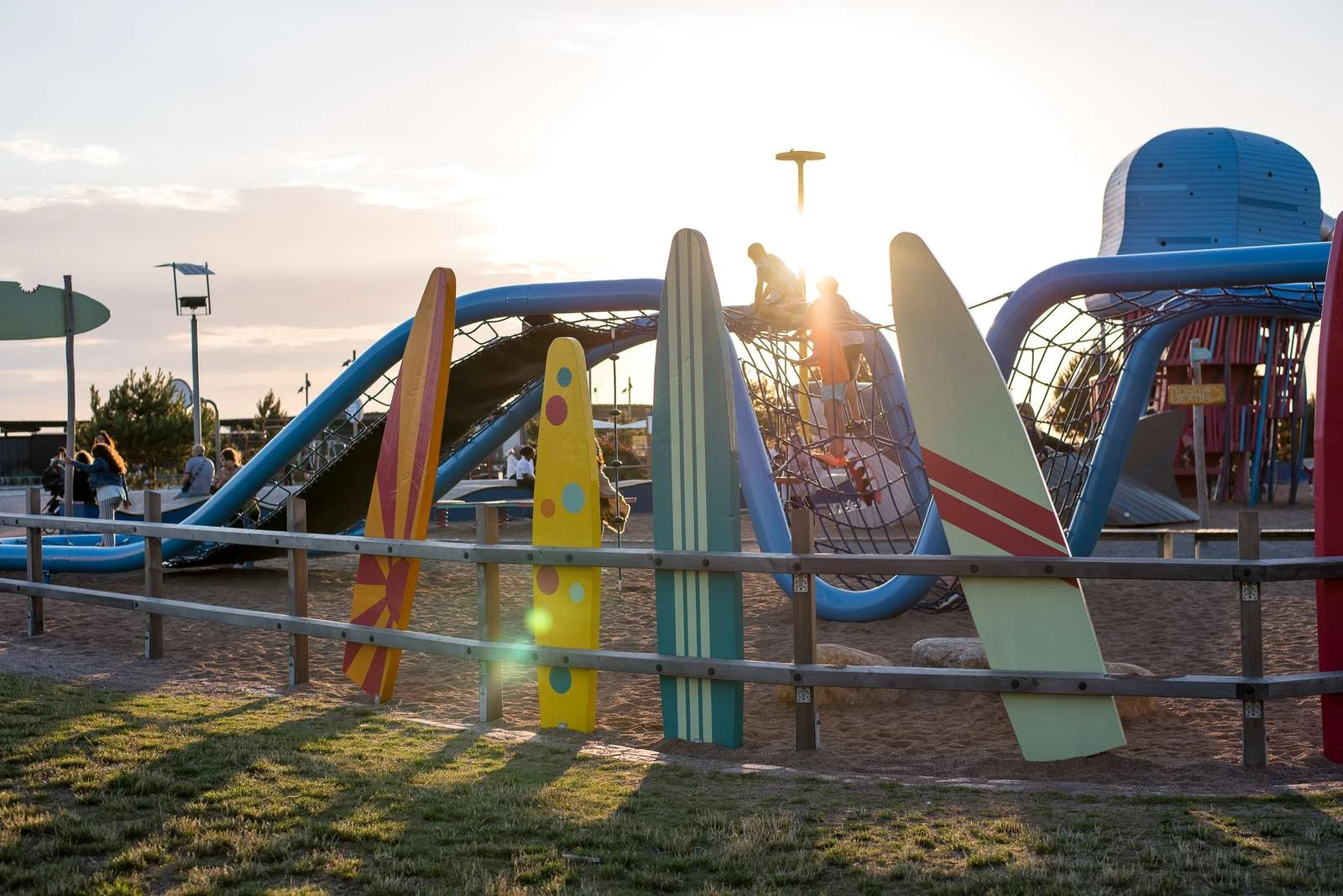 Lekplats med surfbrädor i kvällsljus.