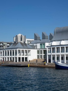 Dunkers Kulturhus sett från hamnen. Båtar framför huset.