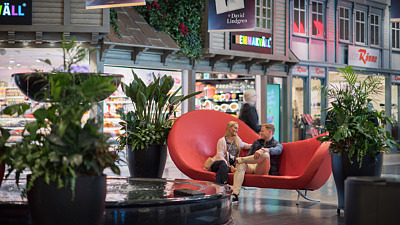 Shoppingcenter väla, ett torg inne på centret med en röd soffa och butiker runt omkring.