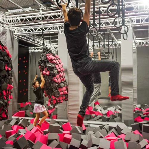 Jumpyard trampolinpark i Helsingborg och deras Ninja Warrior bana. Ett barn hänger i ringarna.