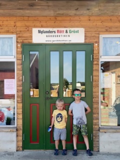 Två barn framför ingången till gårdsbutiken Nylanders Rött och Grönt.