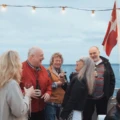 flera personer samtalar uppe på däck på en båt.