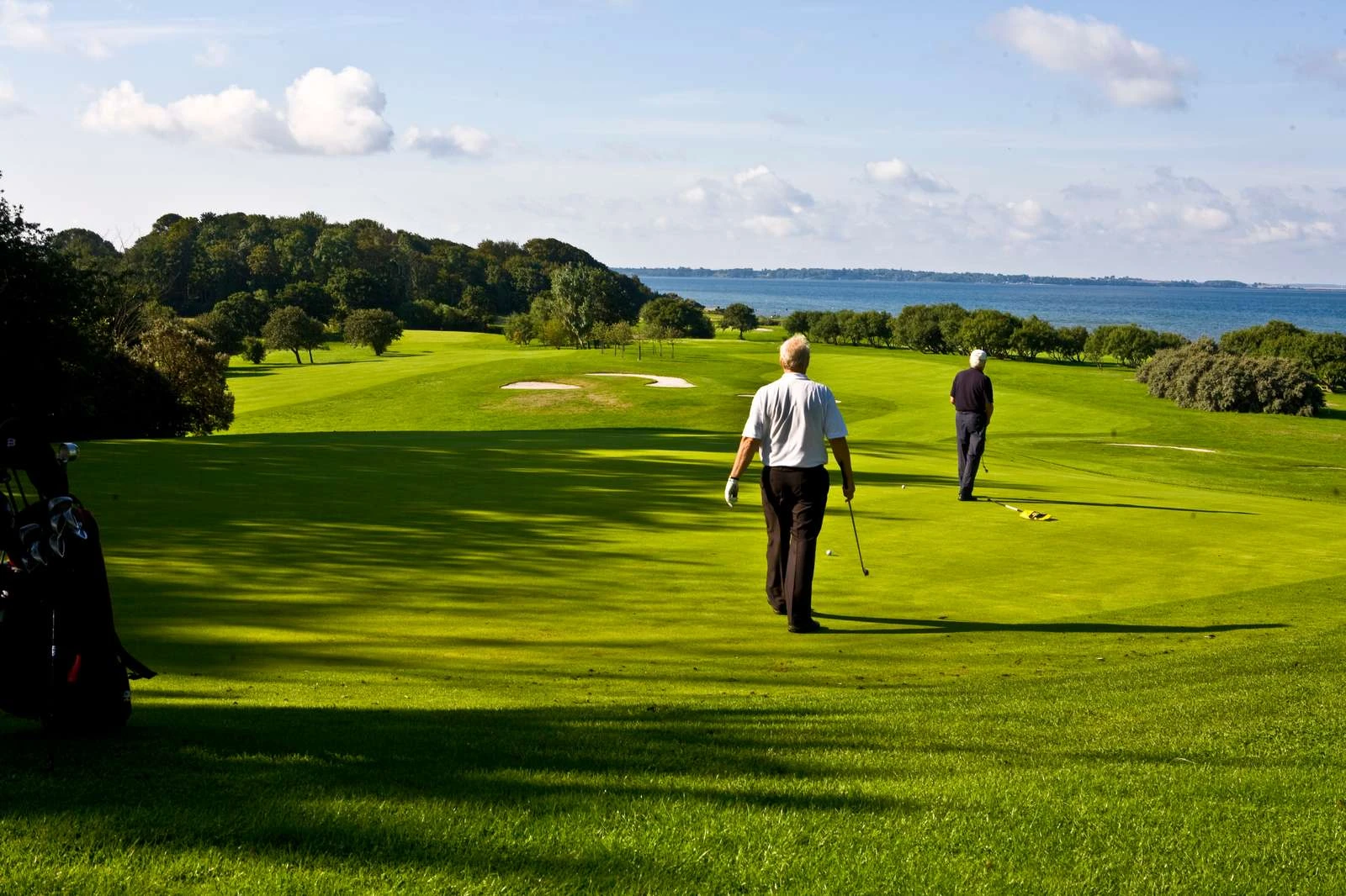 Två golfspelare på Rya golfbana med utsikt över Sundet.