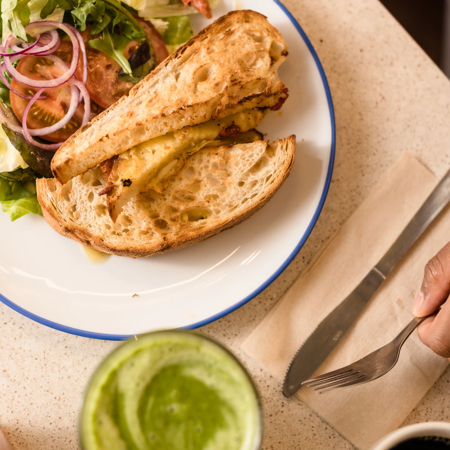 En grillad macka med sallad upplagda på en tallrik.