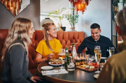 En grupp vänner sitter vid ett bord på en restaurang.