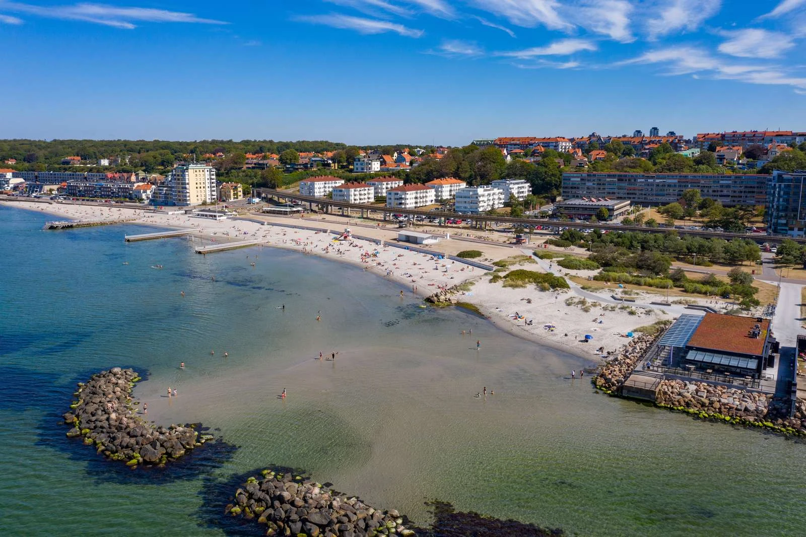 Drönarbild över stranden Fria bad en sommardag. Klart vatten i härligt blå toner.