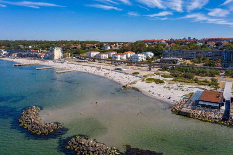 Drönarbild över stranden Fria bad en sommardag. Klart vatten i härligt blå toner.