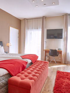 Hotel stadsparken deluxe rum med röda detaljer och två stora fönster