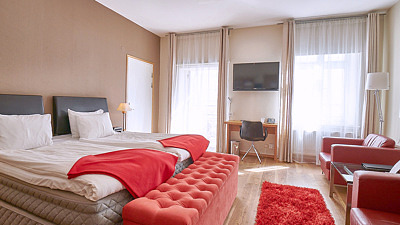Hotel stadsparken deluxe rum med röda detaljer och två stora fönster