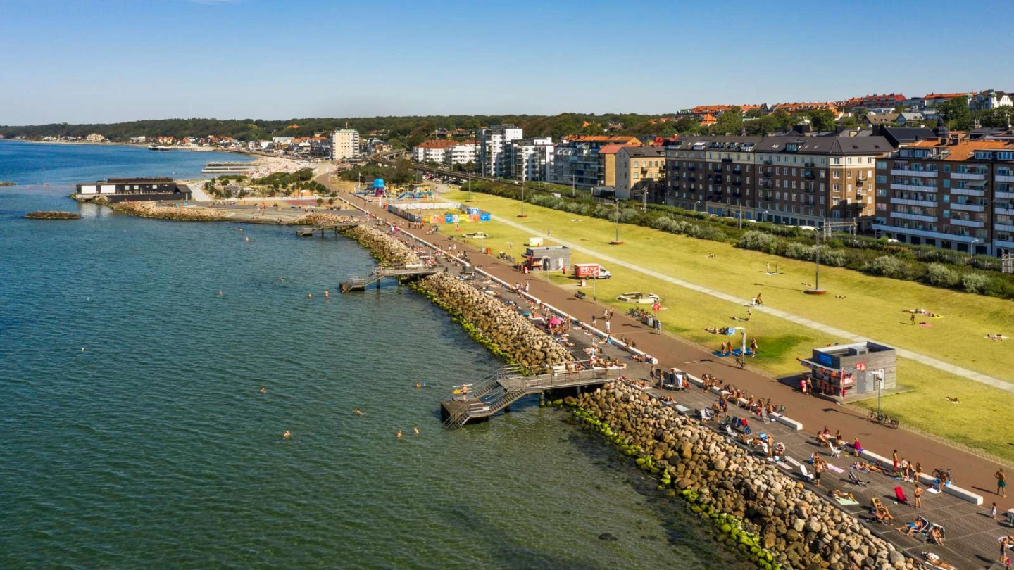 En drönarbild över Gröningen i Helsingborg. Stor gräsmatta med badbryggor ner i havet.