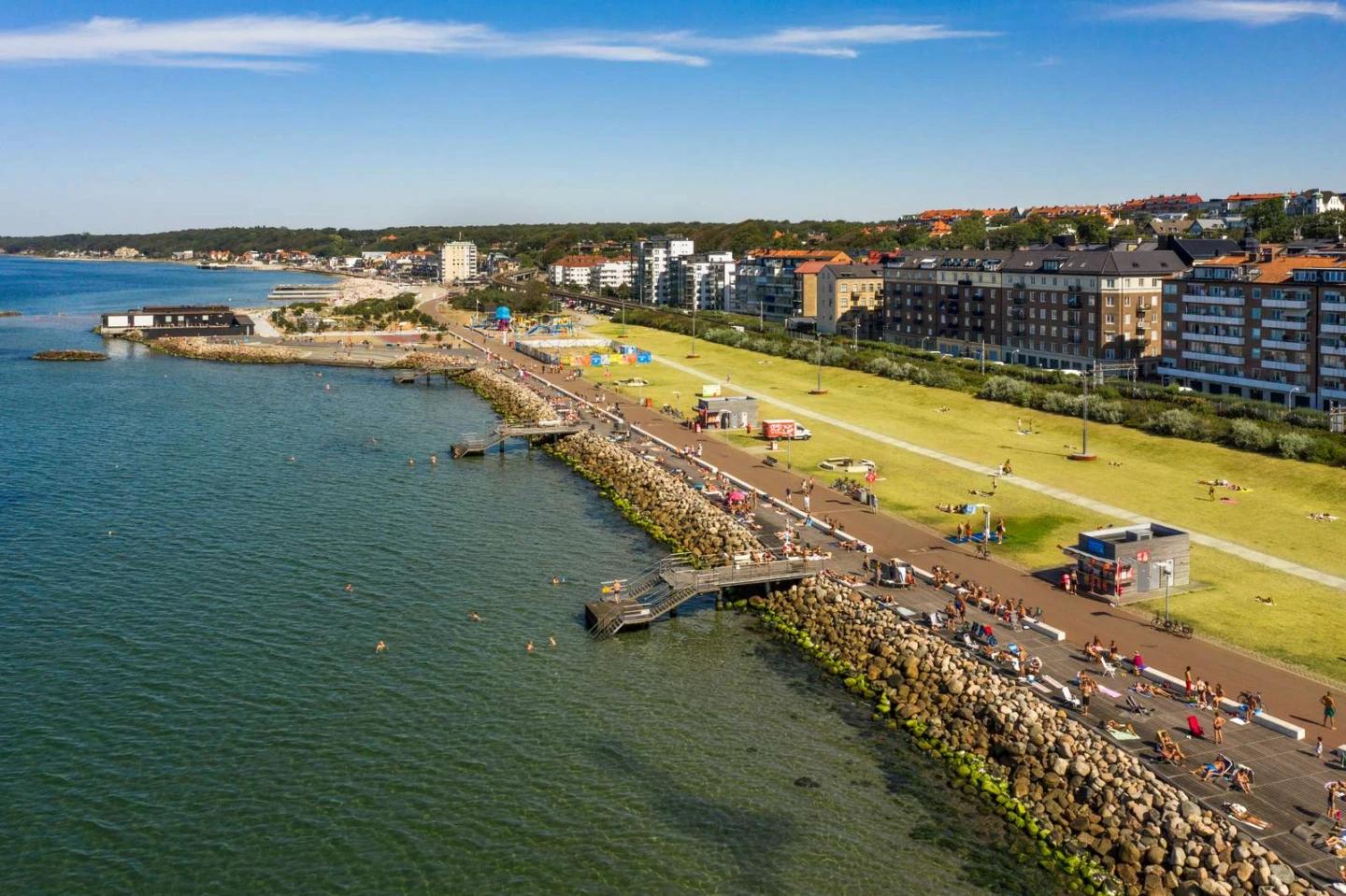 En drönarbild över Gröningen i Helsingborg. Stor gräsmatta med badbryggor ner i havet.