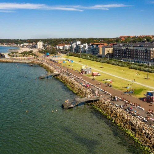 En drönarbild över Gröningen i Helsingborg. Stor gräsmatta med badbryggor ner i havet.